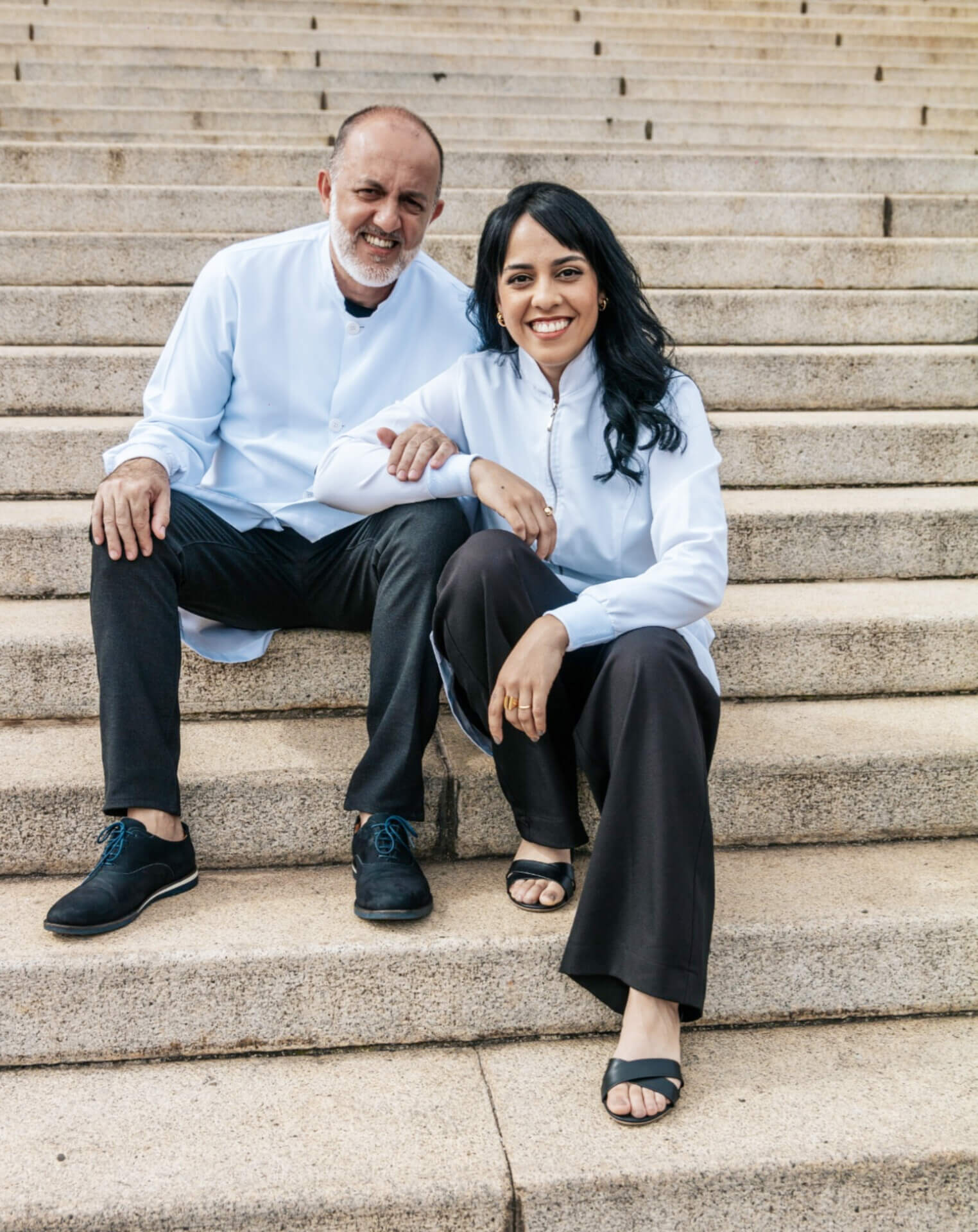 Os doutores e fundadores da MAAC, Dr. Álvaro e Dra. Mariana, sentados e sorrindo.